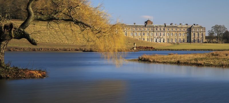 View across the lake to the west front of Petworth House in the Sussex parkland