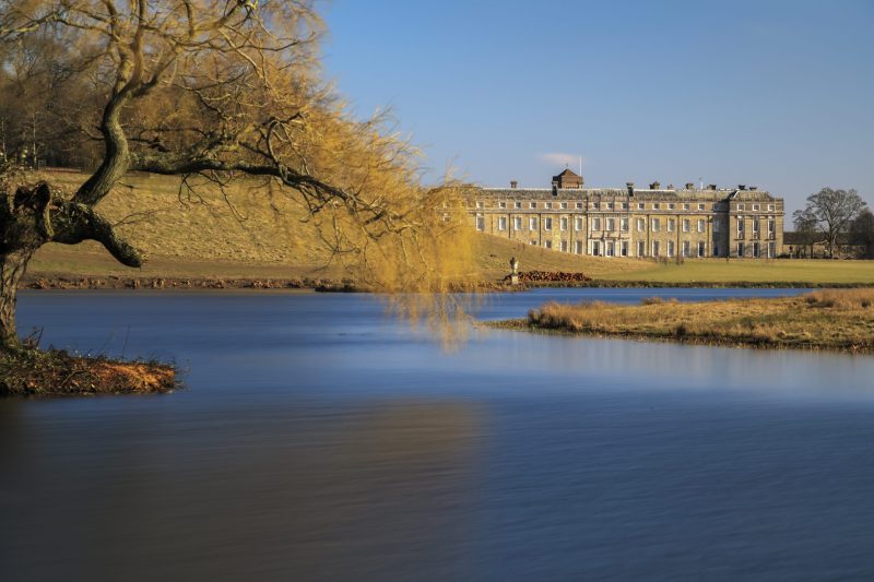 View across the lake to the west front of Petworth House in the Sussex parkland