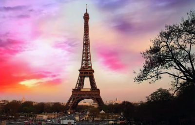 Eiffel Tower during sunset with colorful sky and surrounding park.
