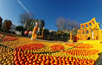Colorful fall festival scene with pumpkins and a historic building.