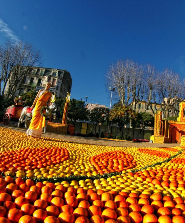 Colorful fall festival scene with pumpkins and a historic building.