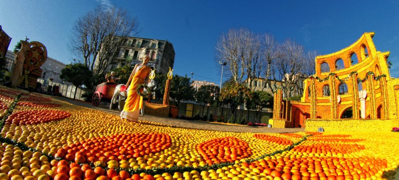 Colorful fall festival scene with pumpkins and a historic building.