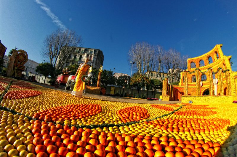 Colorful fall festival scene with pumpkins and a historic building.