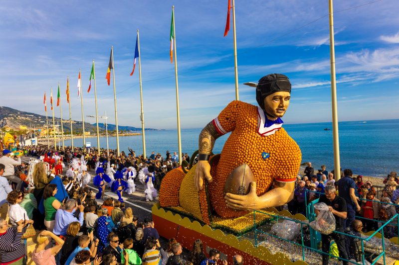 Large parade float of a football player at Pennywood Tours event.